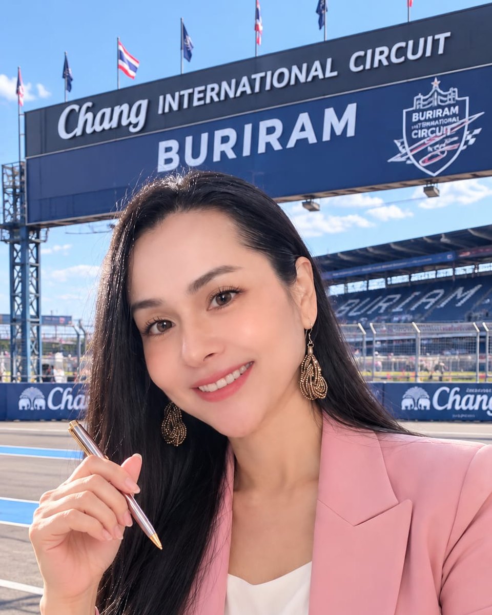 Natalie in a pink blazer, smiling and holding a pen, at Chang International Circuit, Buriram